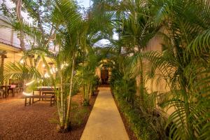 a hallway with palm trees and a table and chairs at Mango House - Galle Fort in Galle