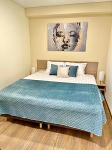una camera da letto con un grande letto e un piumone blu di Alanta Apartments Easy Kaunas a Kaunas