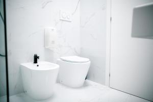 a white bathroom with a toilet and a sink at B&B Best Hostel Milano in Milan