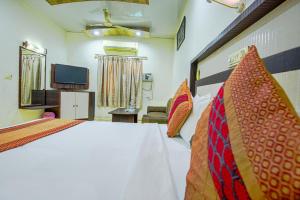 1 dormitorio con 1 cama y TV. en Hotel Surya en Ludhiana