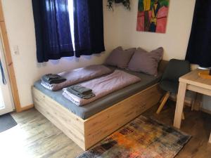 a bed in a room with a table and a chair at Tiny House Black Pearl in Tettnang