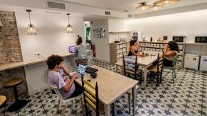 a group of people sitting at tables in a restaurant at Veranera Hostel in Estepona