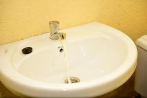 a white sink with water coming out of it at NYUNGWE VILLAGE in Kitabi