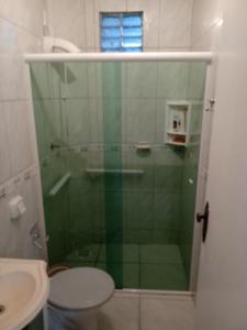 uma casa de banho com um chuveiro, um WC e um lavatório. em Casa a 40 metros da praia em Governador Celso Ramos