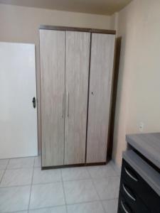 uma cozinha com um grande armário de madeira num quarto em Casa a 40 metros da praia em Governador Celso Ramos