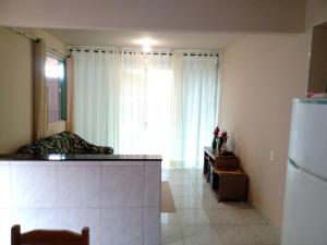 Zimmer mit einer Küche mit einem Kühlschrank und einem Bett in der Unterkunft Casa a 40 metros da praia in Governador Celso Ramos