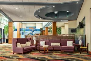 a lobby with two purple couches and a table at Holiday Inn Louisville East - Hurstbourne by IHG in Louisville