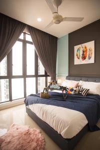 a bedroom with a large bed with a ceiling fan at D'Pristine Medini By The one - 8min walk to Legoland in Nusajaya