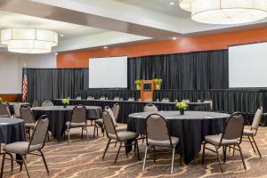 a conference room with tables and chairs and a screen at Holiday Inn Louisville East - Hurstbourne, an IHG Hotel in Louisville