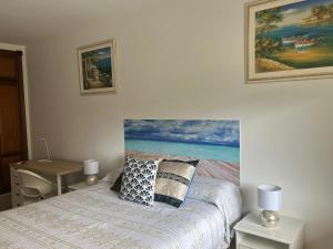 1 dormitorio con 1 cama con una pintura en la pared en Casa Fatima en Santa Cruz de la Palma