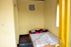 a small room with a small bed in it at NYUNGWE VILLAGE in Kitabi