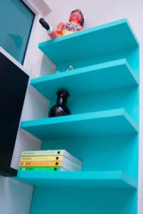 a blue book shelf with a stack of books at Casa RM26 CoLiving & Travel Roma Norte, CDMX in Mexico City
