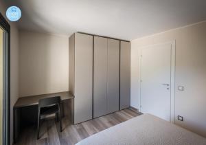 een slaapkamer met een bureau, een bed en een stoel bij Lugano Suites in Gravesano