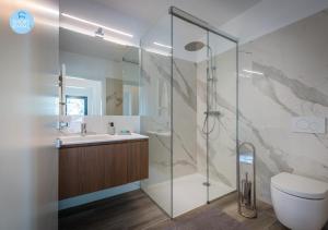 W łazience znajduje się prysznic, toaleta i umywalka. w obiekcie Lugano Suites w mieście Gravesano