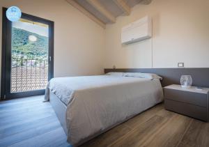 a bedroom with a bed and a large window at Lugano Suites in Gravesano