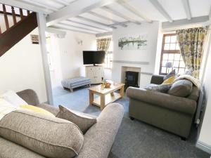 a living room with two couches and a tv at King's Cottage in Bedale