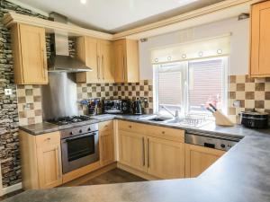 a kitchen with wooden cabinets and a sink at 16 Badgers Retreat in Richmond