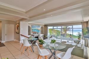 una sala de estar de planta abierta con vistas al océano en Hermanus Beachfront Lodge - Solar Power en Hermanus