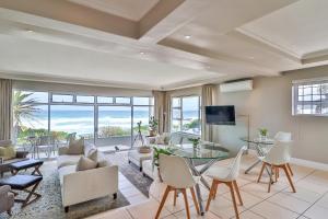 ein Wohnzimmer mit einem Sofa und einem Tisch in der Unterkunft Hermanus Beachfront Lodge - Solar Power in Hermanus