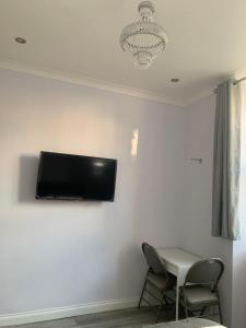 um quarto com uma televisão de ecrã plano na parede em Ibrox Argyll Sky Suite em Glasgow