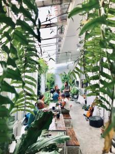 un groupe de personnes assises dans une pièce avec des plantes dans l'établissement The PARK Society, à Chiang Mai