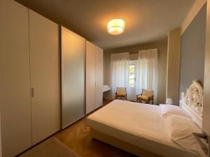 a bedroom with a large white bed and a window at Address Home I Colori Del Mare in Ospedaletti