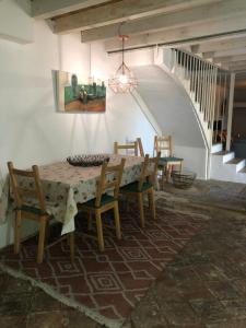Un comedor con mesa y sillas y una escalera. en Casa de la vega, en Almodóvar del Río