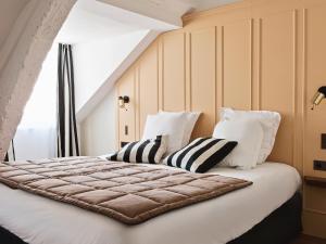 1 dormitorio con 1 cama grande con almohadas blancas en New Hotel Lafayette, en París