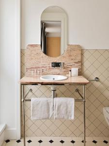 een badkamer met een wastafel en een spiegel bij New Hotel Lafayette in Parijs