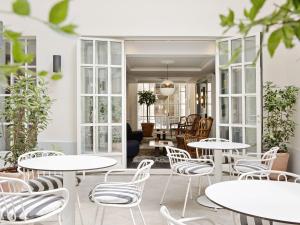 een kamer met tafels en stoelen en een woonkamer bij New Hotel Lafayette in Parijs
