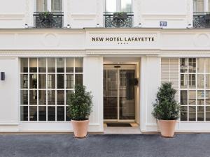 un edificio con due piante in vaso di fronte ad esso di New Hotel Lafayette a Parigi