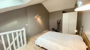 sypialnia z białym łóżkiem i schodami w obiekcie Appartement vue mer, Brigantine w mieście Fort-Mahon-Plage