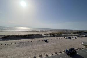 plaża z samochodami zaparkowanymi na piasku i oceanie w obiekcie Appartement vue mer, Brigantine w mieście Fort-Mahon-Plage