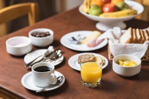 una mesa con platos de comida y un vaso de zumo de naranja en Hotel Big Sur, en Puerto Natales