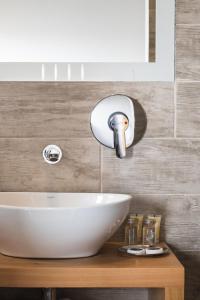 lavabo blanco en una encimera de madera en el baño en Hotel Big Sur, en Puerto Natales