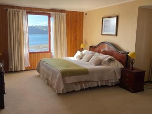1 dormitorio con 1 cama y vistas al océano en Cabañas Posada Alemana, en Castro