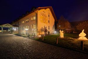un edificio con estatuas delante de él por la noche en Hotel Linderhof, en Erfurt