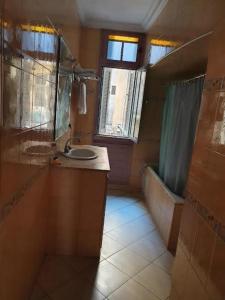 een badkamer met een wastafel en een bad bij HOTEL DU LOUVRE in Casablanca