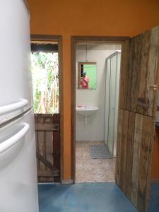 a bathroom with a toilet and a sink and a mirror at Casinhas Vila Bonita Azul in Baía Formosa