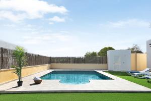 a swimming pool in a yard next to a fence at Villa Montenmedio - Juande in El Soto
