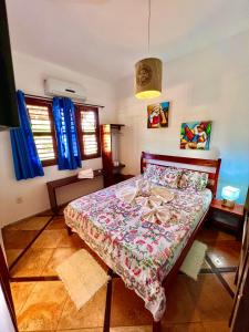 a bedroom with a bed in a room with blue curtains at Residencial Bem-te-vi in Jericoacoara