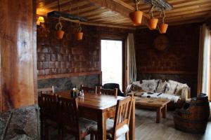 a dining room with a wooden table and a couch at LONQUIMAY LODGE in Lonquimay
