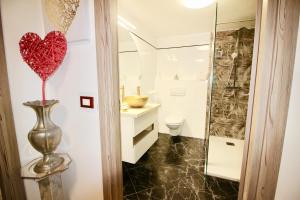 a bathroom with a red heart on the wall at Casa Heli II in San Zeno di Montagna +23 photos