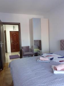 1 dormitorio con cama, silla y espejo en Stan na dan VRŠAC, en Vršac