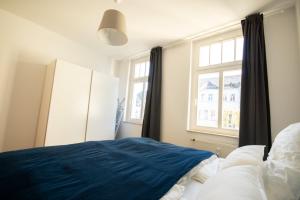 ein Schlafzimmer mit einem blauen Bett und einem Fenster in der Unterkunft Wunderschön gepflegter Altbau, Aufzug in Chemnitz