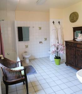 a bathroom with a toilet and a sink and a chair at Hotel De Pastorij in Leuven