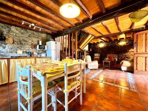 a kitchen with a table and chairs in a room at Casa con 2 dormitorios, chimenea, jardin y vista a la montaña in Campomanes