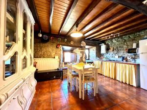 uma grande cozinha com uma mesa e um balcão em Casa con 2 dormitorios, chimenea, jardin y vista a la montaña em Campomanes