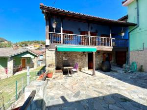 Blick auf ein Haus mit einer Terrasse in der Unterkunft Casa con 2 dormitorios, chimenea, jardin y vista a la montaña in Campomanes