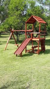 a wooden playground with a bench and a gazebo at Bungalows Estacion El Molino in San José